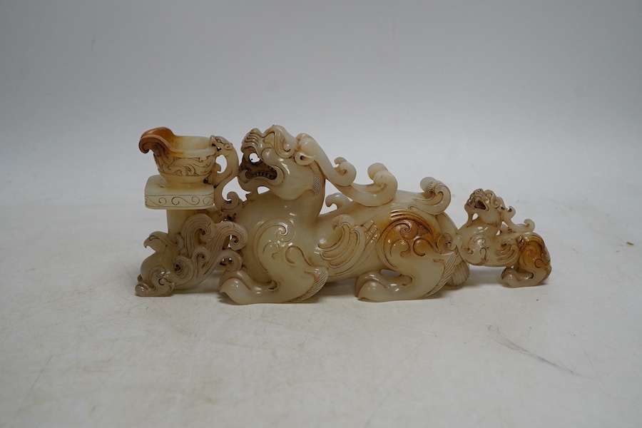 A Chinese archaistic white and russet jade lion-dog group, 20cm long. Condition - good